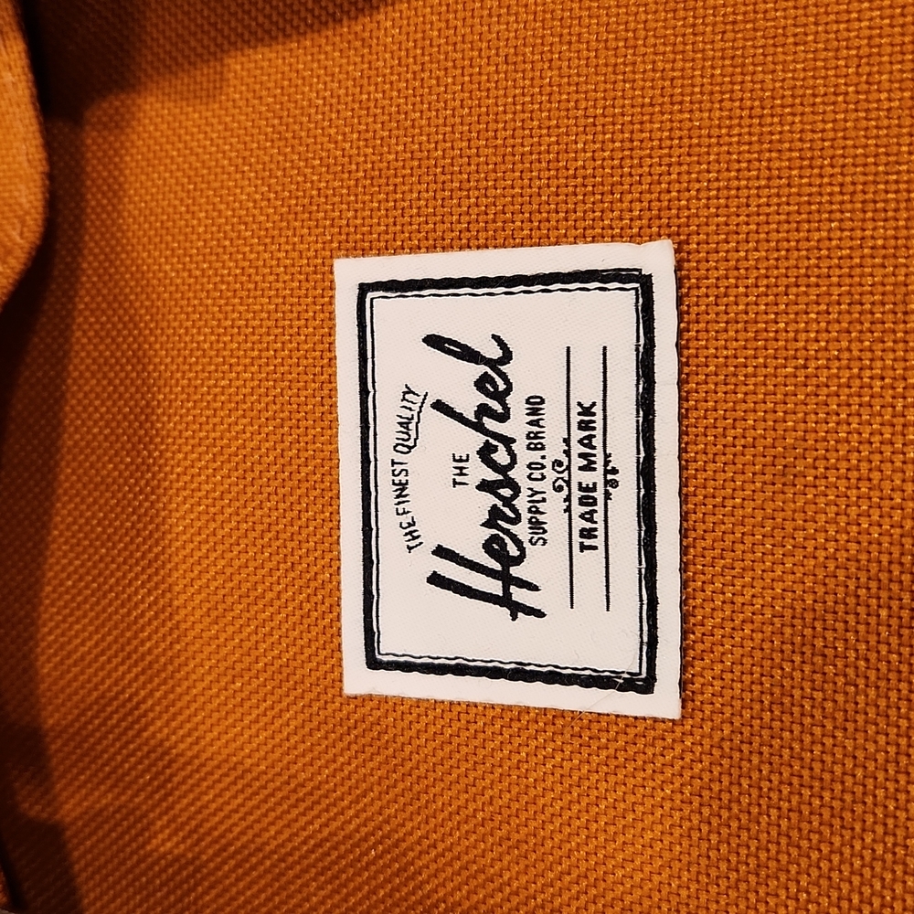 Herschel backpack with front zip and foldover pocket, rust in color